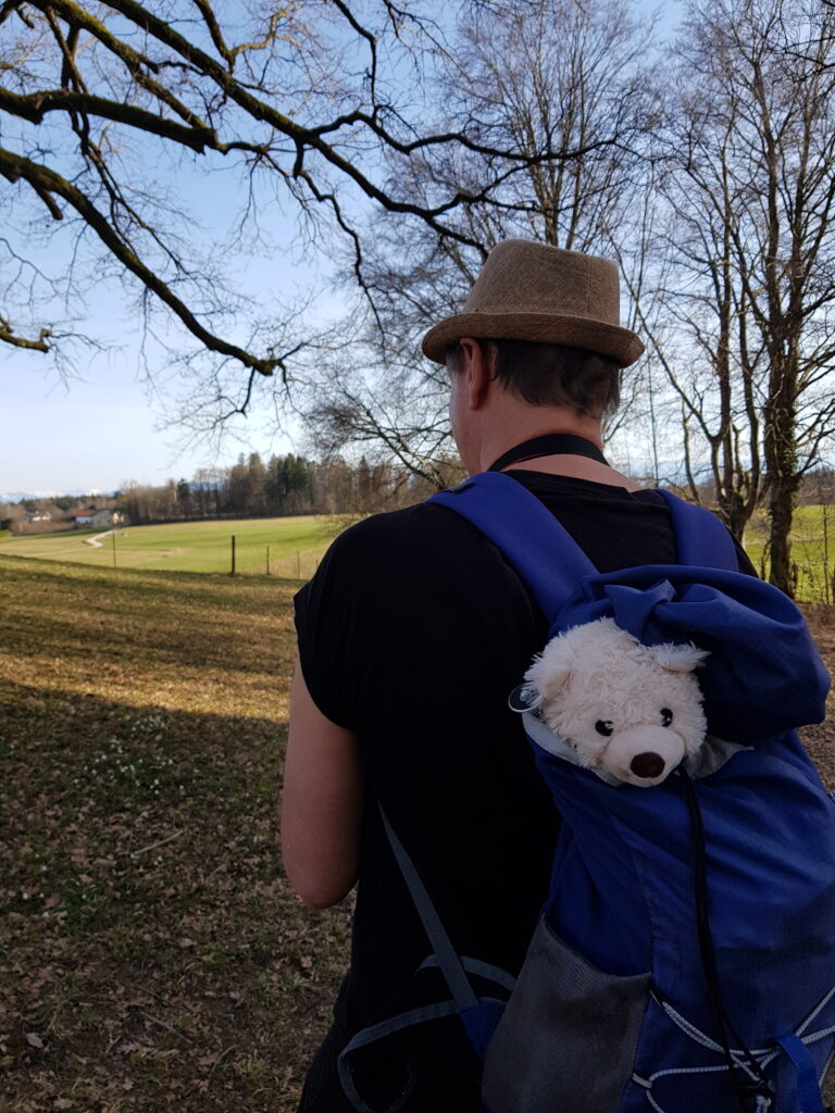 Ehemann mit Teddybär in Rucksack beim Wandern im Starnberger Umland