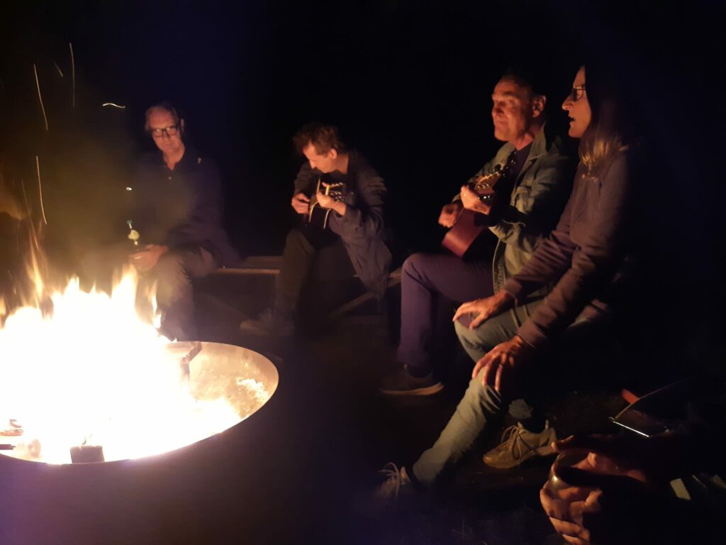 Gemeinsames Singen und Musizieren am Lagerfeuer unter dem Sternenhimmel