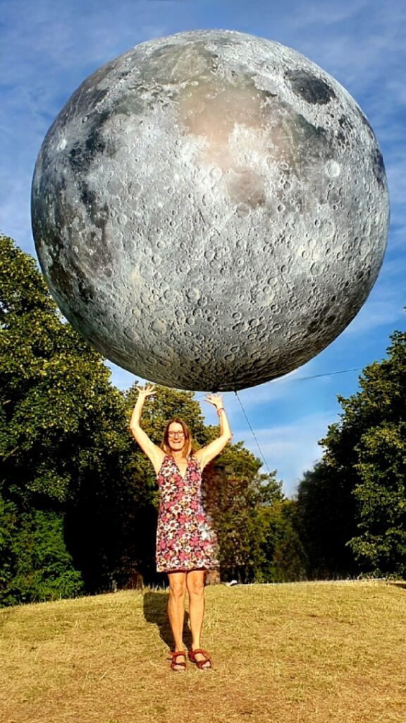 Kathrin Günther trägt scheinbar den Riesenmond auf dem Tolllwood, einem Modell, das durch einem Kran in der Luft hängt als Dekoration