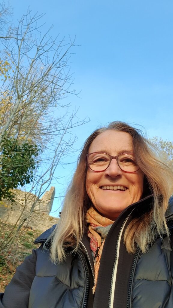 Kathrin Günther bei einer Wanderung zur Burg Botenlauben, dem ältesten Sinnbild von Bad Kissingen im Abendlicht. Kathrin lächelt zufrieden